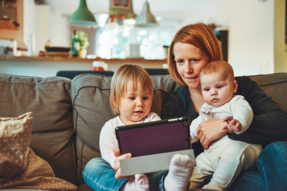 Mom with two kids on a tablet - alexander-dummer-150646